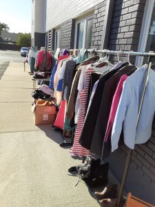 rack of used clothing outside a building